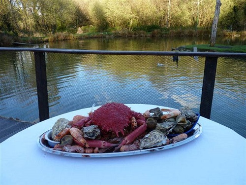 Photo du plateau de Fruit de mer sur une table à nappe blanche en face de l'étang.